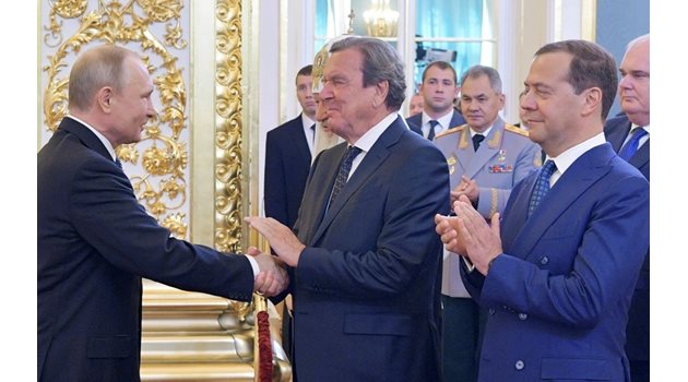 Владимир Путин се ръкува с Герхард Шрьодер след встъпването си в длъжност в Кремъл. Вдясно - руският премиер Дмитрий Медведев аплодира президента.