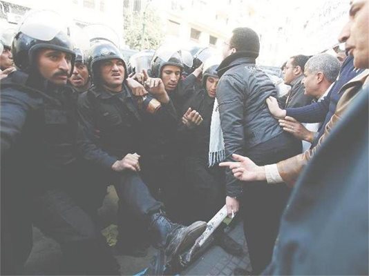 Полицаи опитват да спрат демонстрантите в египетската столица Кайро.
СНИМКА: РОЙТЕРС
