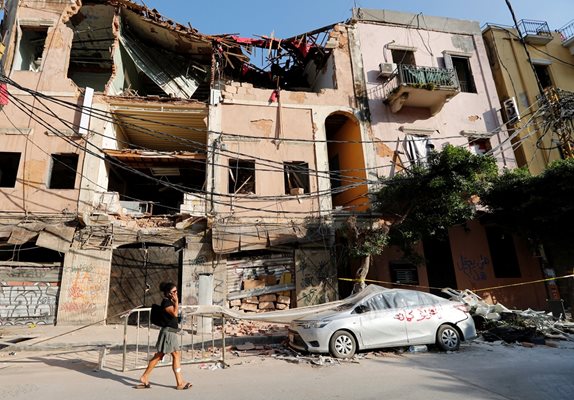 Жена минава покрай руините, които останаха след експлозията в Бейрут. Снимка: Ройтерс