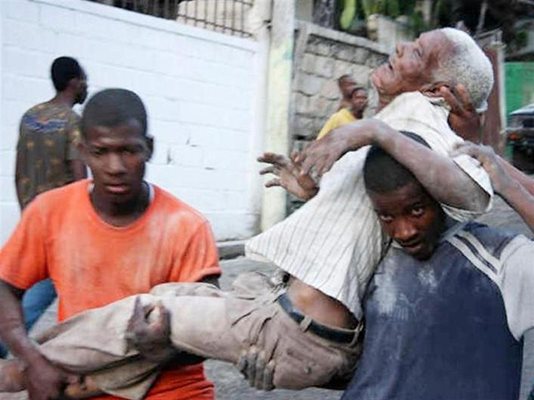 Мъже пренасят роднина, ранен от земетресението в Порт-о-Пренс. 
СНИМКИ: РОЙТЕРС
