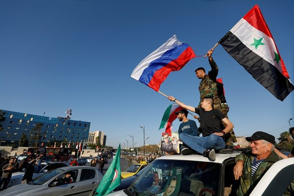 Сирийски войници развяват руско и сирийско знаме  СНИМКА: Ройтерс