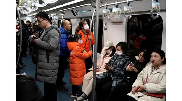 Китайци пътуват с маски в метрото в Пекин.