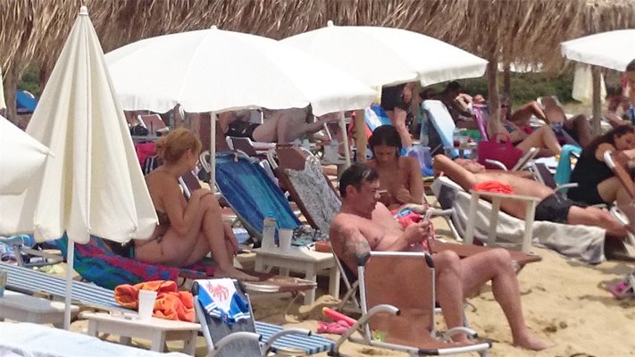 Иван Ласкин и Александра Сърчаджиева на шезлонга зад актьора, снимани на плажа в Неа Перамос, курорт на около 18 км от Кавала. 