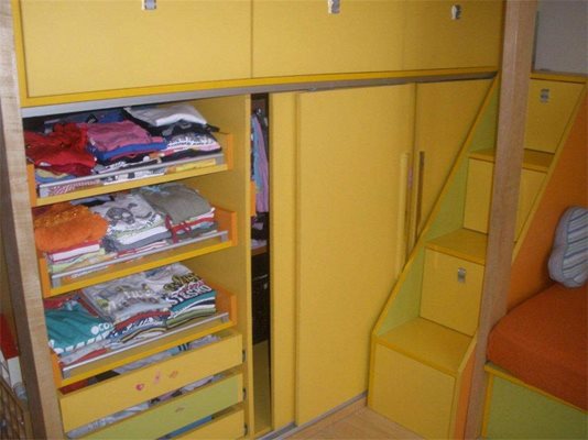 Стълбите, по които хлапетата се качват към двете легла на второ ниво, са чекмеджета, които побират книжки, играчки и други детски вещи.