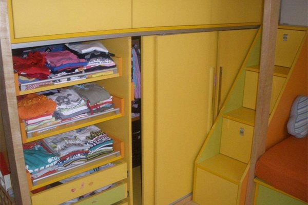 Стълбите, по които хлапетата се качват към двете легла на второ ниво, са чекмеджета, които побират книжки, играчки и други детски вещи.