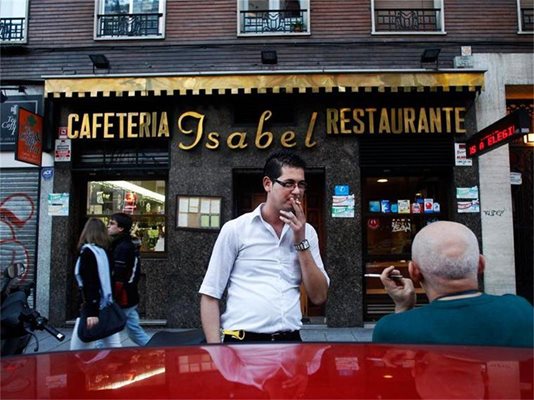 Испанци пушат пред ресторант в Мадрид.