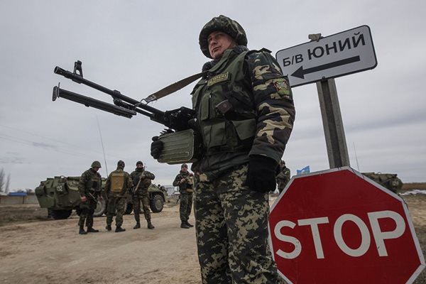 Украински войници пазят на пропускателен пункт до село Стрелково в Херсонска област, близо до Крим.