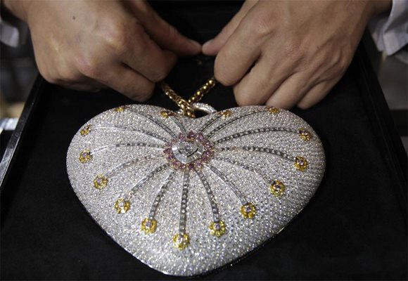 Продавач показва дамска чантичка с диаманти “1001 нощи” по време на изложение на бижутерия и часовници в Доха. Аксесоарът е изработен  от елементи от 18-каратово злато и 4517 диаманта и се оценява на 3,8 млн. долара. Клиентите в Катар са едни от най-платежоспособните в света, смятат бижутерите.