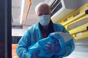 Фелдшерът Радко Радев с изроденото бебе на ръце.