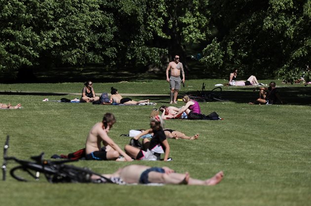 Британци се пекат на слънце в парк в Лондон.