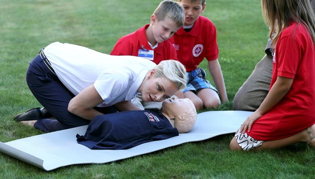 Принцесата на Монако Шарлийн, посланик на добра воля в Международната федерация на Червения кръст и Червения полумесец, показва основни правила за първа помощ на деца.