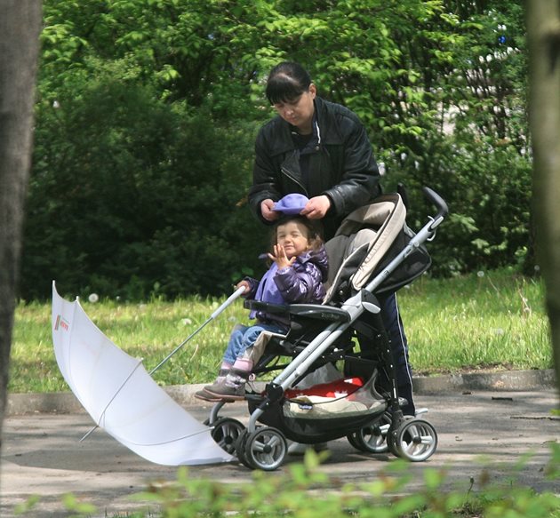 Майка разхожда детето си в парк в столицата. Майките са едни от малкото социално групи, за които има бонуси в новия осигурителен бюджет.