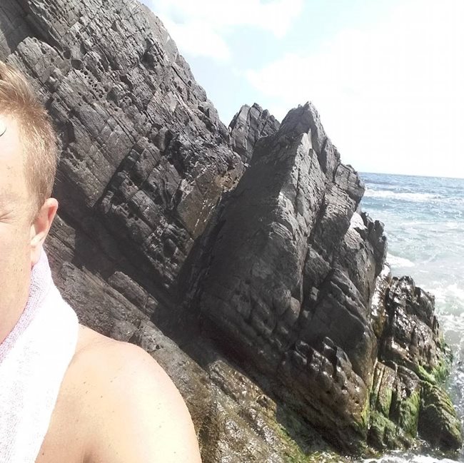 Васил Драганов снима ухото си, а на заден фон е морето.