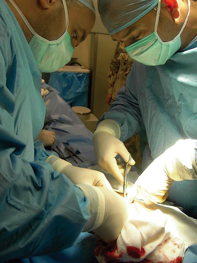 Опита, натрупан на война, хирургът (вдясно) прилага и в операционната на ВМА.