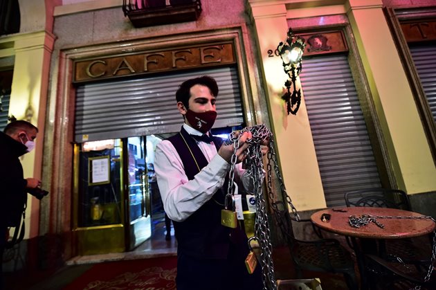 Келнер затваря кафене в Торино след въвеждането на нови ограничителни мерки в Италия.