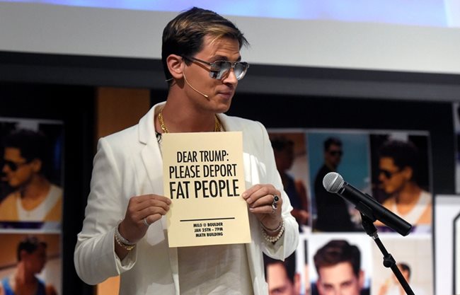 Майло държи флаер с надпис “Скъпи Тръмп, моля те, депортирай дебелите хора”, рекламиращ лекцията му в Боулдър.