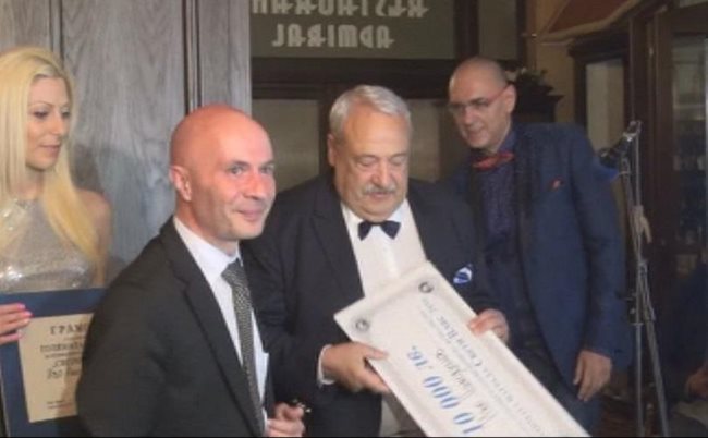 Иво Никодимов получава наградата си от Иван Гарелов, който е член на “Кръг 11”. Зад тях се вижда Любен Дилов, също от журито. СНИМКА: АРХИВ