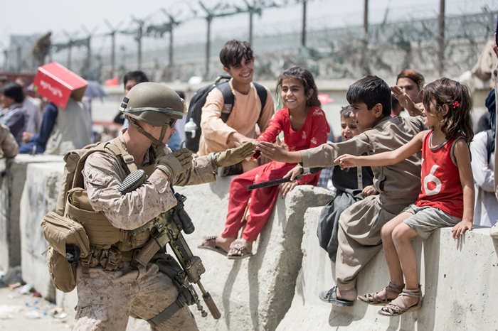 Американски войник си играе с афганистански деца на летището в Кабул.