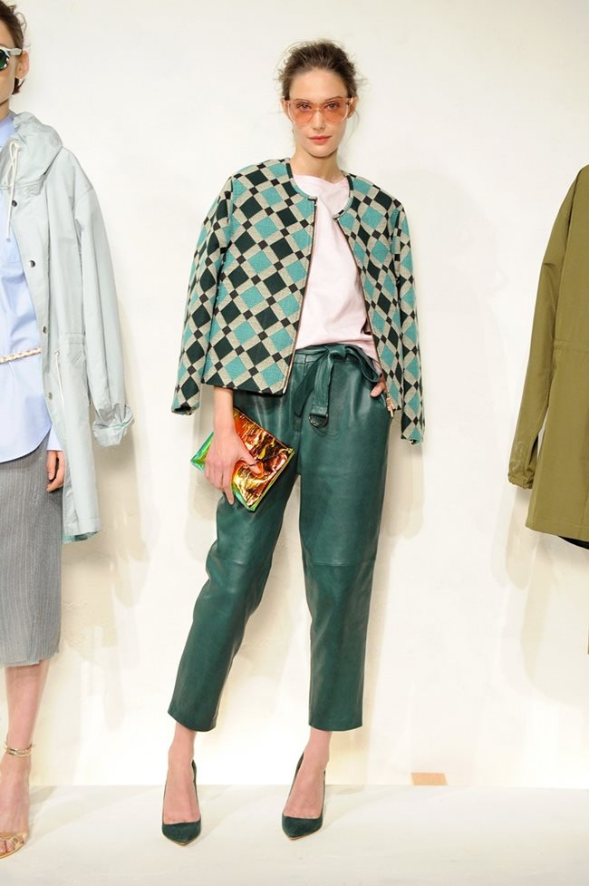 Модел позира със зелен кожен панталон, комбиниран с блейзър с принт на ромбове – също сред актуалните десени този сезон.
