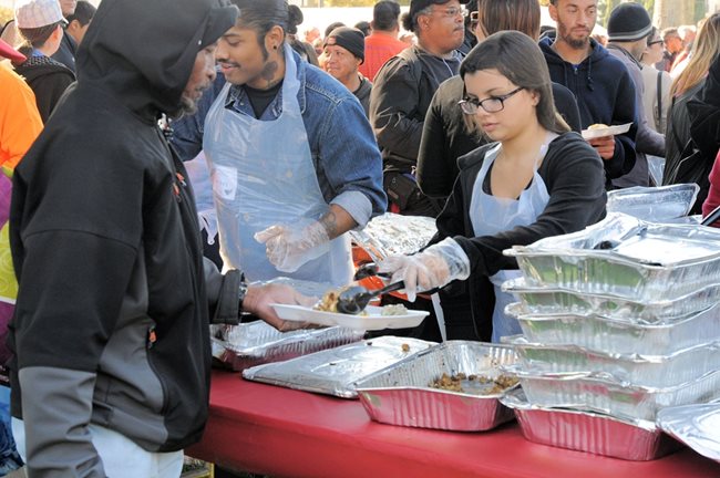 Младежи сервират храна на бездомни в обществена кухня в Тексас.