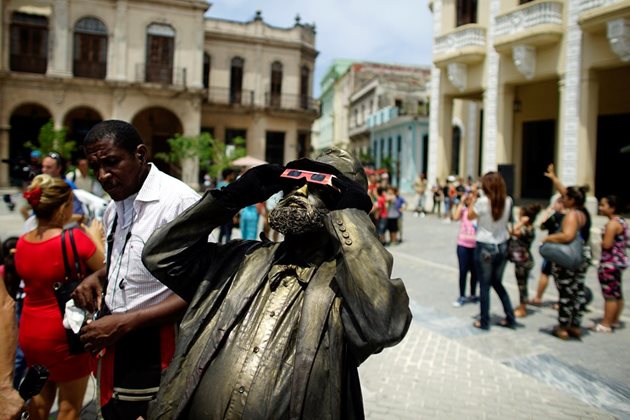 Кубинци гледат затъмнението в Хавана.