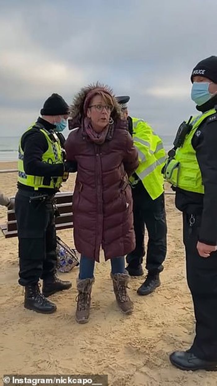 Британски полицаи арестуват жена, седяла на пейка край морето без маска в Бърнмаут.
СНИМКА: ИНСТАГРАМ