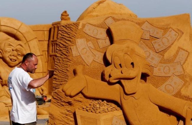 Белгийски плаж се превърна в гигантска галерия с огромни супергерои, анимационни любимци и замък на Пепеляшка за един от най-големите фестивали на пясъчните скулптури. Снимка: Ройтерс