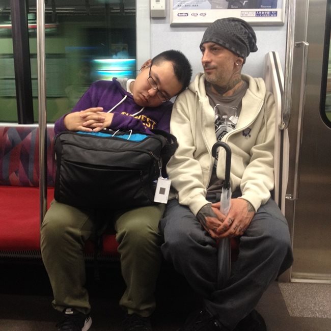 Млад мъж се е облегнал да поспи на рамото на Михалчев, докато пътува в метрото.