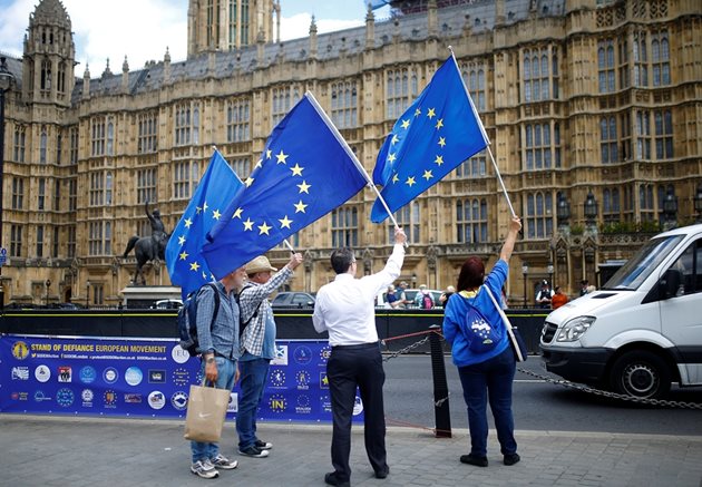 Противници на Брекзит развяват знамената на ЕС пред парламента в Лондон.