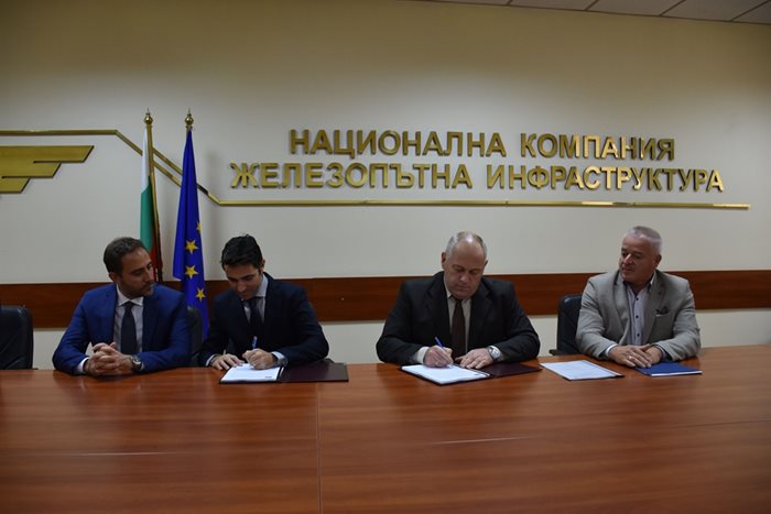 Шефът на НКЖИ Красимир Папукчийски (вторият от дясно на ляво) подписва договора с представители на фирмите в консорциума.
