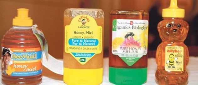 На снимката само един от четирите буркана с мед е обозначен като канадски, но не съдържа 100% канадски мед, а останалите три са произведени от други водещи компании, но медът е смес с вносен.