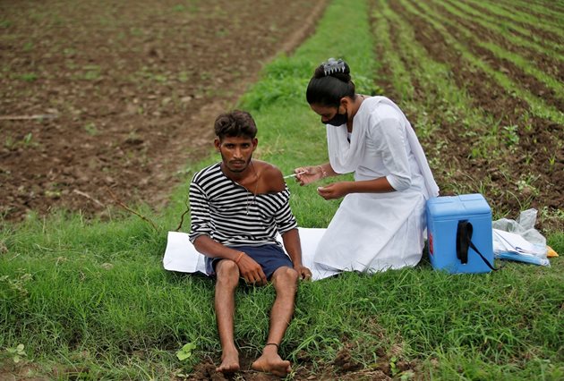 Медсестра ваксинира индийски селянин направо на полето. 
СНИМКИ: РОЙТЕРС