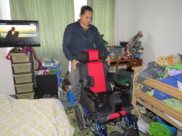 Майката показва модерната количка за деца с увреждания.