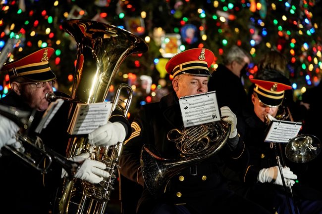 Музиканти свирят по време на запалването на светлините на коледното дърво пред Капитолия