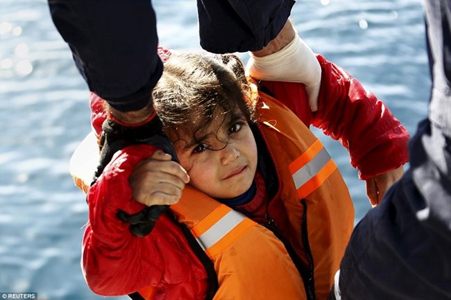 Гръцката брегова охрана спасява малко момиченце от лодки, пълни с бежанци, край остров Лесбос.