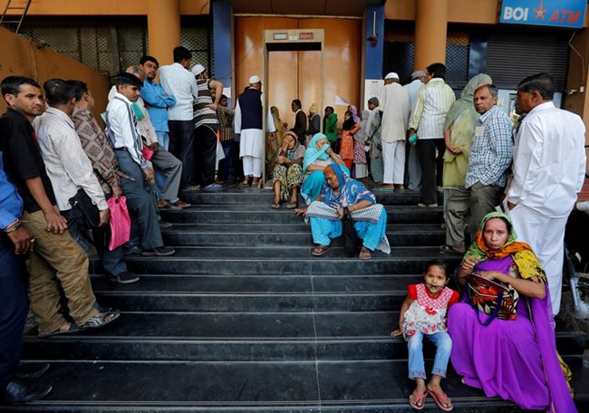 Хората чакат пред банките, за да обменят парите си след обезценяването на банкнотите от 500 и 100 рупии  СНИМКИ : Ройтерс