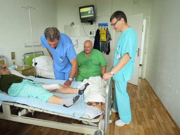 Д-р Красимир Георгиев (вляво) и колегите му д-р Пламен Денчев и д-р Ангел Григоров проследяват състоянието на възрастна пациентка.