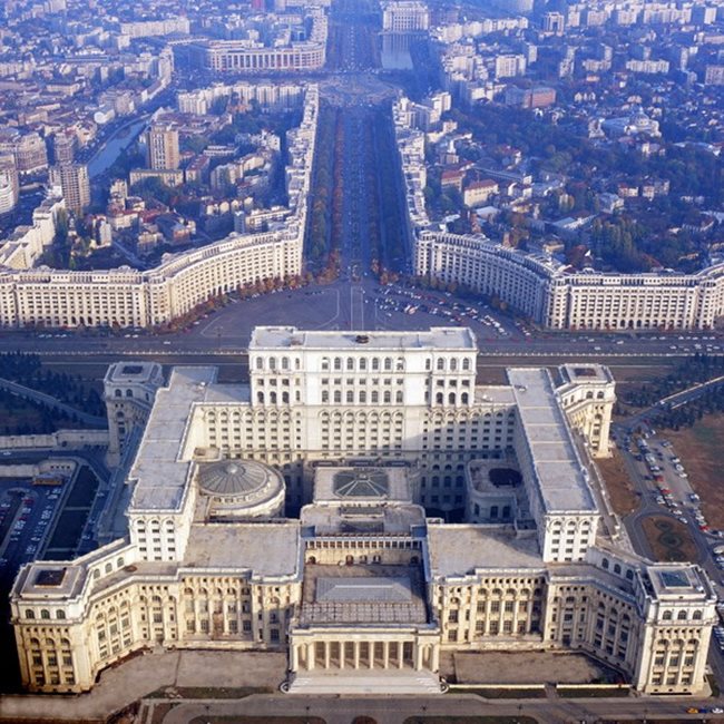Дворецът на парламента в Букурещ. Смята се за най-голямата сграда в света, която е с административни функции. Площта е 350 000 кв. м, на които са разположени 1100 помещения. Строежът започва през 1984 година по поръчка на комунистическия диктатор Николае Чаушеску. Проектът е на румънската архитектка Анка Петреску.